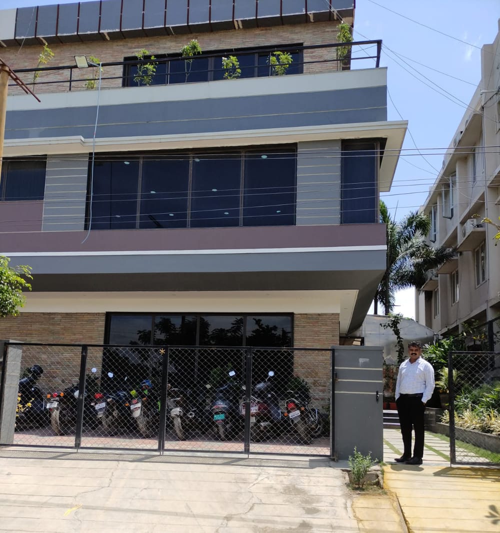 The Web Wonder Works office in Coimbatore, a three storey building on Kalapatti Main Road with the team's motorcycles parked inside the gate